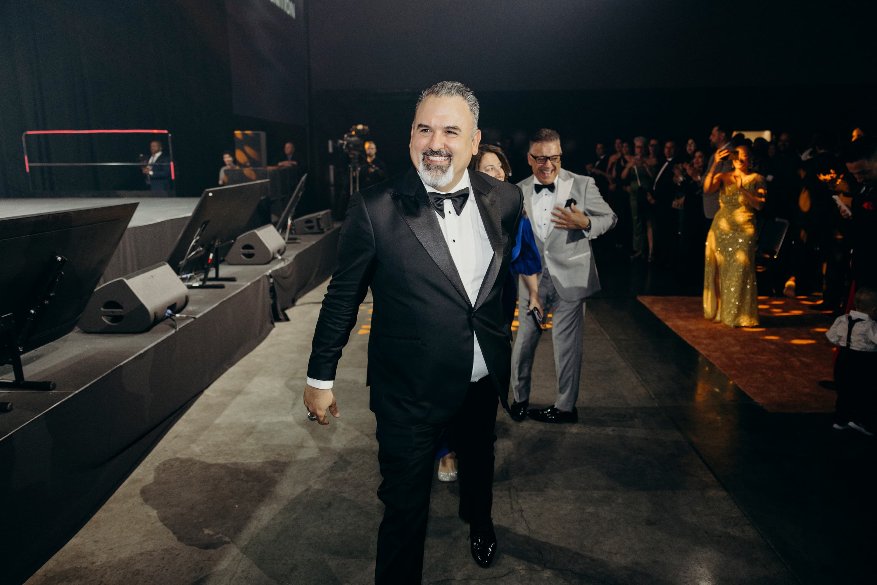 Frank Delio in a tuxedo walking through an evening event