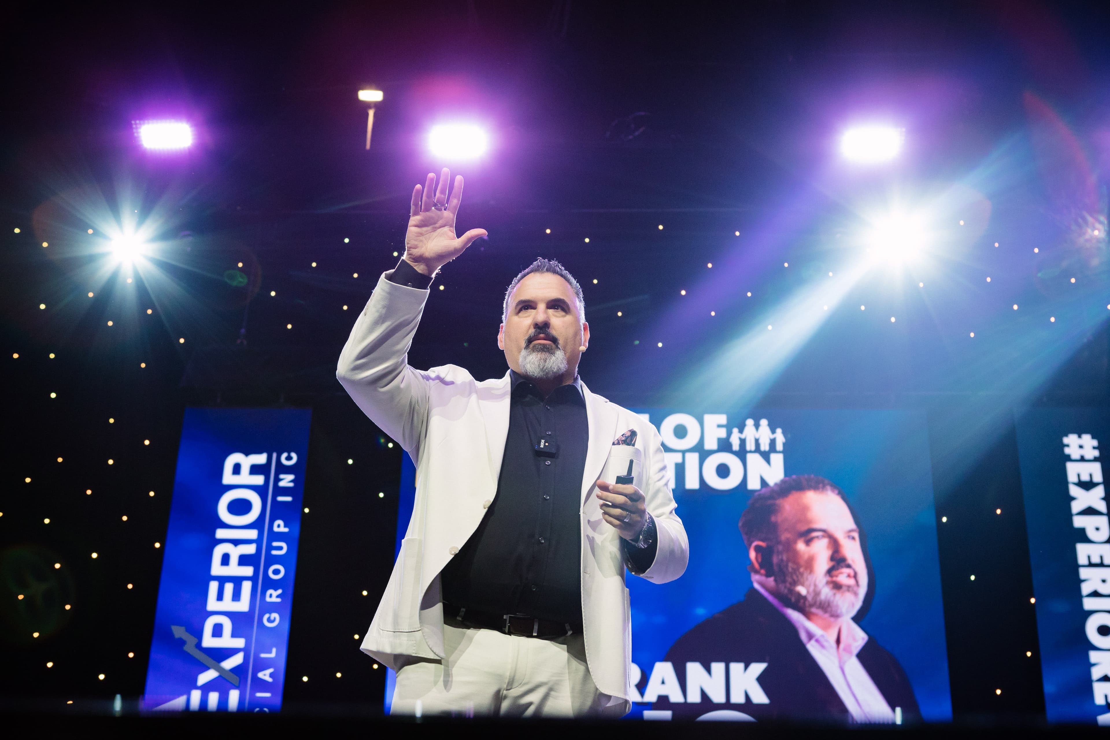 Frank Delio addressing an audience on stage